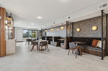 A modern dining area with a glass wall and a patterned wallpaper.